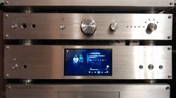 Audio device panel with aluminum finish and display showing a music player interface