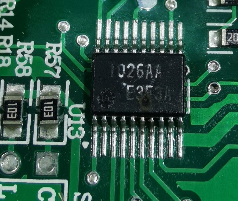 Zbliżenie na PCB z układem scalonym U13 z nadrukiem „1026AA E3F” i sąsiednimi elementami SMD