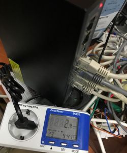 Network switch with Ethernet cables connected and a PeakTech 9035 power meter showing 2.1 W
