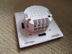 Rear view of a white Axus touch light switch with terminals labeled L, N, 1, 2, 3.
