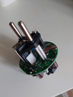 Interior of a Disassembled Electric Plug A disassembled electric plug with visible electronic components on a green PCB.