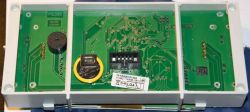 Widok wewnętrzny płytki PCB z baterią, głośnikiem i złączem w plastikowej obudowie