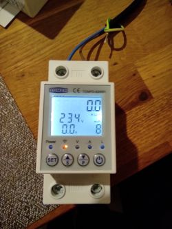 TOMZN electronic energy meter on a wooden table.