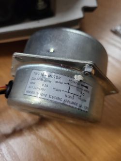 Silnik TWT-10-4 z etykietą techniczną, widoczny z boku na drewnianym tle