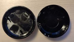 Case of IRC03 Universal Infrared Remote Two black circular case components with holes and notches.