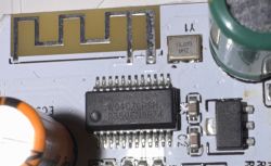 Close-up of a circuit board with IC, 16 MHz crystal, and PCB antenna trace