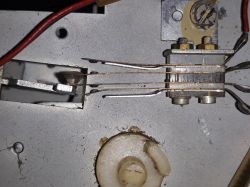 Zbliżenie na część urządzenia elektronicznego z kablami i stykami.