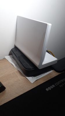 Biały router sieciowy stojący na czarnej podstawce na biurku.