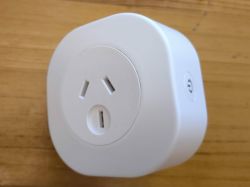 White Electrical Plug White cube-shaped electrical plug on a wooden surface.