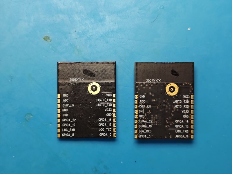 Two black PCB boards with pin labels lying on a blue work mat