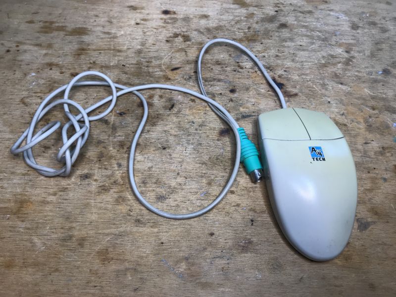 Old A4Tech Mouse with PS/2 Connector Old A4Tech computer mouse with PS/2 connector on a wooden table.