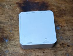 Shutter Controller Casing QS-WIFI-ECC02 White casing of a shutter controller on a wooden background.