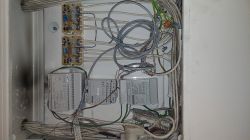 Skrzynka systemowa z przewodami i modułami w bloku mieszkalnym.