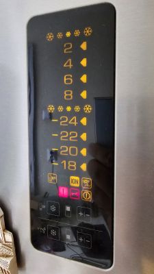 Panel sterowania lodówki z włączonymi wszystkimi kontrolkami.
