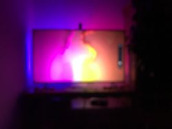 TV with dynamic LED backlighting in purple, pink, and yellow tones