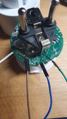 Open interior of an electrical plug showing wired connections and electronic circuitry.