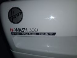 Zbliżenie na logo Hoover oraz oznaczenie modelu pralki H-WASH 300.