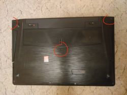 Spód laptopa Lenovo y510p z zaznaczonymi miejscami brakujących śrubek.