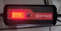 Prostownik Ultimate Speed z wyświetlaczem LCD pokazującym napięcie 13,4V.