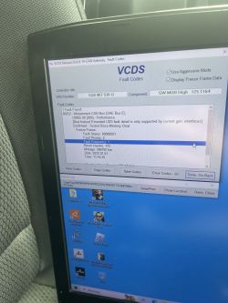 Laptop z błędami VCDS na ekranie w samochodzie.