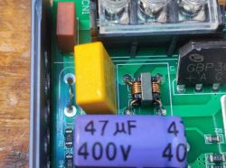 Inside of a power supply showing common mode choke and capacitors clearly