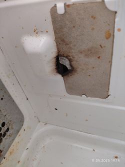 Wnętrze brudnej mikrofalówki z wypaloną, nadpaloną płytką po boku.