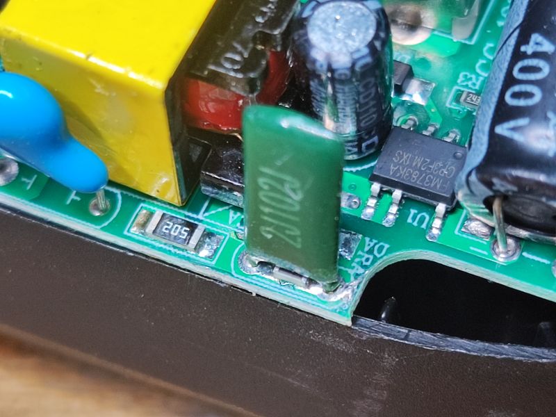 Zbliżenie na wnętrze elektronicznej listwy zasilającej z widocznymi elementami elektronicznymi.