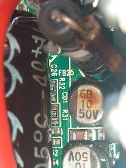Zbliżenie na płytkę PCB z rezystorami SMD, cewką i kondensatorem oznaczonym „6B 10 50V”.