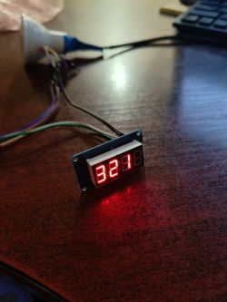 LED display showing the number 321 on a wooden desk.