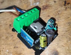 PCB with electronic components including capacitors and a green screw terminal block.