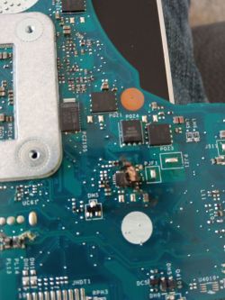 Beschädigte Laptop-Mainboard mit einem ausgebrannten integrierten Schaltkreis.