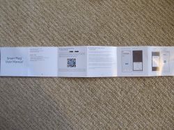 Smart Plug User Manual Smart plug user manual unfolded on the floor.
