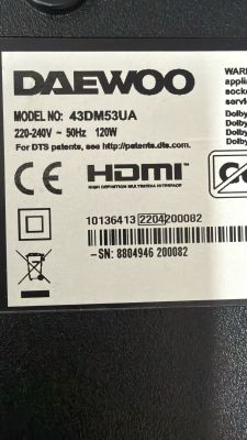 Daewoo TV label showing model 43DM53UA, power specs, compliance marks, and barcodes.