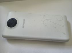Biała, lekko zabrudzona powerbanka ROMOSS 20+ leżąca na jasnej powierzchni.
