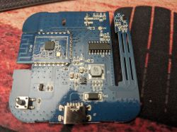 Blue PCB with a Bluetooth module and USB‑C port on a red-and-black surface