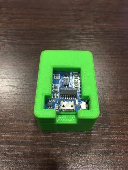 Adapter for flashing ESP8266 12F in a green case.