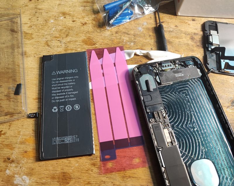 iPhone Battery Replacement Disassembled iPhone battery and screen during replacement.