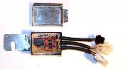 Moduł elektroniczny opóźniający w metalowej obudowie z widocznymi przewodami i elementami