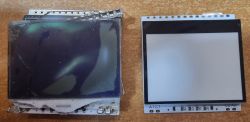 Dwa prostokątne elementy elektroniczne na stole: po lewej uszkodzony wyświetlacz LCD, po prawej podświetlenie do LCD.
