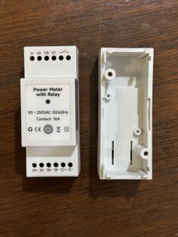 Power meter with relay and casing on a wooden surface