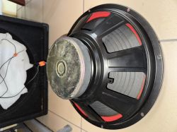 Tył głośnika z czarnym koszem i dużym magnesem, czerwone elementy widoczne przez otwory
