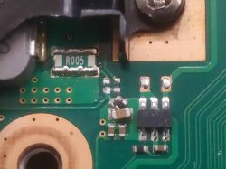 Close-up of a circuit board with visible electronic components, including a resistor marked R005.