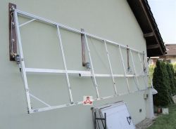 Aluminiowa konstrukcja montażowa na siłownikach przymocowana do elewacji budynku