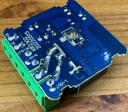 Platine eines intelligenten Schalters Zerleg-te Platine eines intelligenten Schalters mit Markierungen und gelöteten Leiterbahnen auf einem hölzernen Hintergrund.