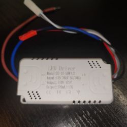 Biała obudowa z napisem „LED Driver” i przewodami czerwonym, niebieskim oraz białymi na ciemnym tle