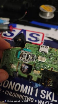 Zbliżenie na uszkodzoną płytkę drukowaną z wyeksponowanymi elementami elektronicznymi