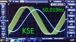 Ekran oscyloskopu Rigol z dwiema sinusoidami i napisem „50,019Hz” oraz „KSE”.