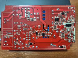 Czerwona płytka PCB z lutowanymi podzespołami elektronicznymi