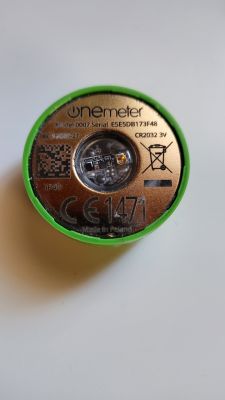Licznik OneMeter z widoczną etykietą z numerem modelu i seryjnym.