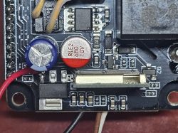 Close-up of a PCB with capacitors, ICs, and a connector socket